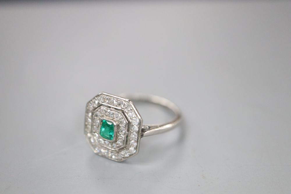 An Art Deco white metal, emerald and diamond set octagonal tablet ring, (emerald chipped), size J/K, gross 3.4 grams.